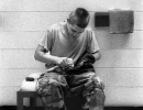 A young inmate polishes boots