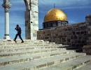 An Israeli soldier walks past the Dome of the Rock, Jerusalem.